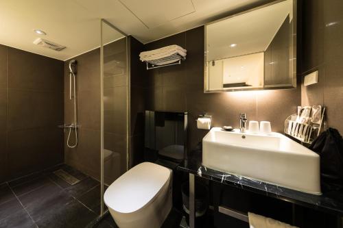 台北的住宿－凡登台北商務旅店，浴室配有卫生间、盥洗盆和淋浴。