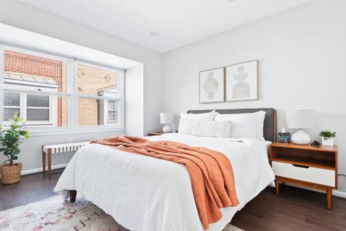 biała sypialnia z łóżkiem z pomarańczowym kocem w obiekcie The BEST Gorgeous & Luxurious Home Walk to Metro w mieście Arlington