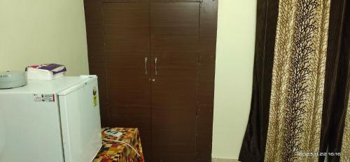 a wooden cabinet next to a refrigerator in a kitchen at Viva la Veda in Karunāgapalli