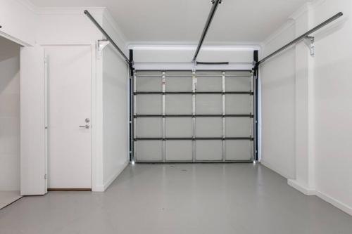 an empty garage with white walls and doors at Perfect Port Melbourne Townhouse in Melbourne