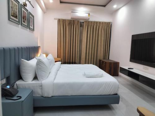 a hotel room with a bed and a television at The Hoften Elite 32 Avenue, Sector 15, Gurugram in Gurgaon
