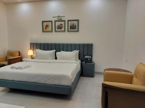 a bedroom with a large bed and a chair at The Hoften Elite 32 Avenue, Sector 15, Gurugram in Gurgaon