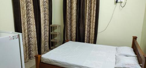 a bedroom with a bed and a window with curtains at Viva la Veda in Karunāgapalli