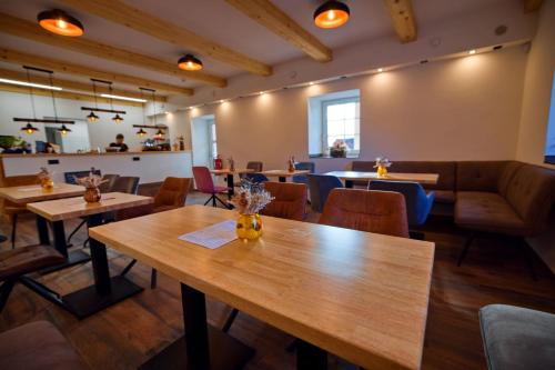 a dining room with wooden tables and chairs at Penzion pod Hazmburkem in Klapý