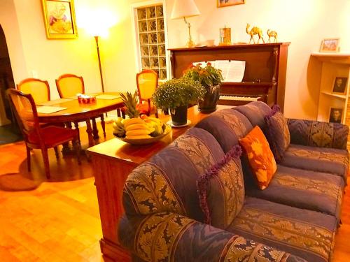 a living room with a couch and a table and a piano at Lovely comfy home private bath in central Calgary in Calgary