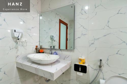 La salle de bains est pourvue d'un lavabo et d'un miroir. dans l'établissement HANZ Noi Bai Airport Hotel, à Hanoï