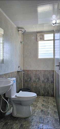 a bathroom with a toilet and a sink at LausDeo1 self checkin 2BHK AC corner flat top floor in Trivandrum