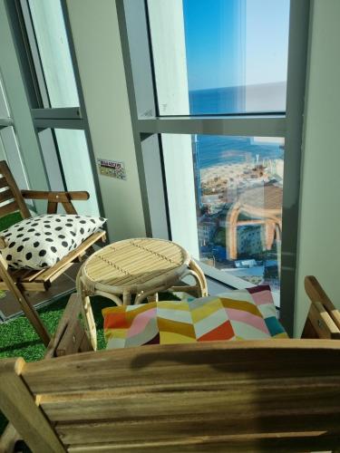 a room with a bed and a chair and a window at Haeundae Elbon The Stay in Busan
