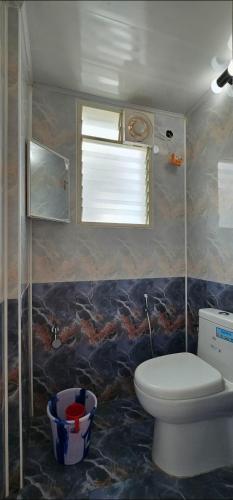 a bathroom with a toilet and a sink and a window at LausDeo1 self checkin 2BHK AC corner flat top floor in Trivandrum