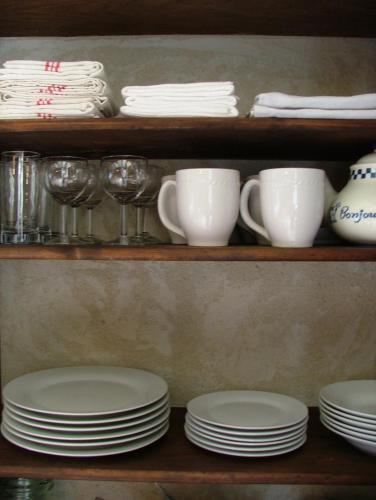 a shelf with plates and cups and dishes on it at Gites De L'Etang Des Noues in Cholet