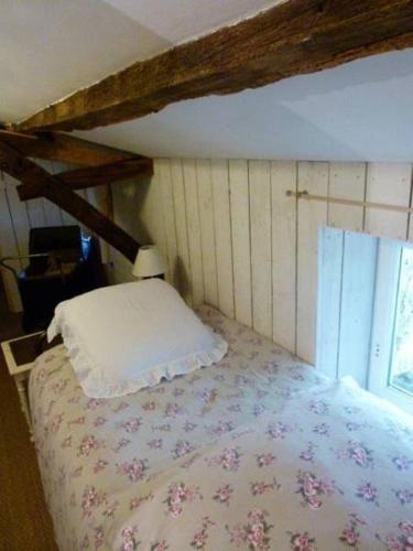a bedroom with a bed with a pillow and a window at Gites De L'Etang Des Noues in Cholet