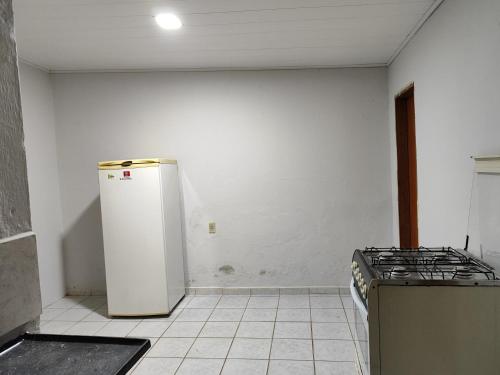 an empty kitchen with a refrigerator and a stove at Casa inteira in Solânea