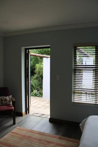 a bedroom with a door open to a yard at Jedidja Bed and Breakfast in Bloemfontein