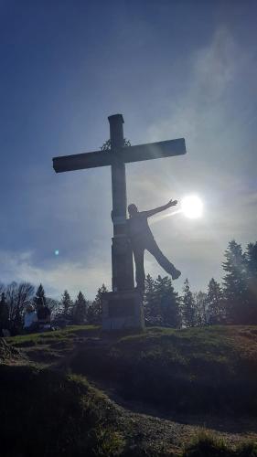 a statue of a man standing in front of a cross at Ferienwohnung Bonny in Schlitters