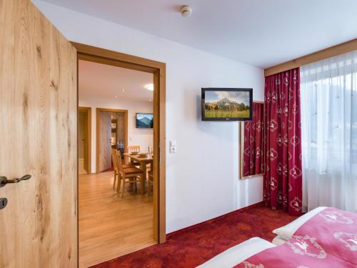 a bedroom with a door leading to a dining room at Hotel Feichter in Söll