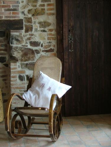a wicker rocking chair with a pillow on it at Gites De L'Etang Des Noues in Cholet