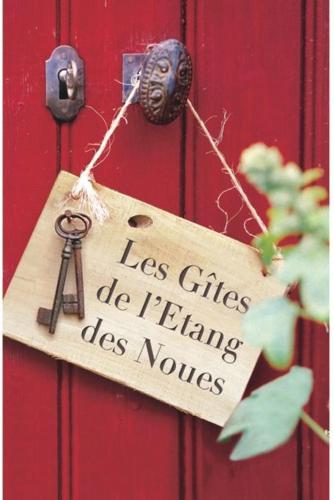 a sign hanging on a red door with a key at Gites De L'Etang Des Noues in Cholet