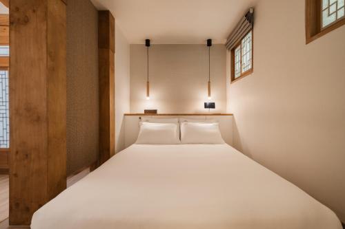 a bed in a room with two lights above it at Luxury Hanok Bliss Cottage in Seoul