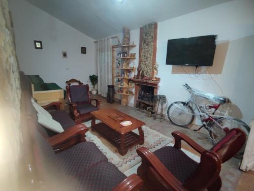 chalet el ghaba في Ben Metir: غرفة معيشة مليئة بالأثاث وتلفزيون بشاشة مسطحة