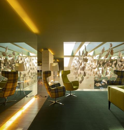 a room with chairs and a wall with a painting at Monverde - Wine Experience Hotel - by Unlock Hotels in Amarante