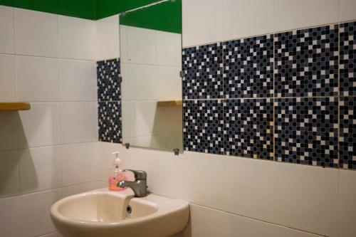 a bathroom with a sink and a mirror at ViaVia Guesthouse in Yogyakarta
