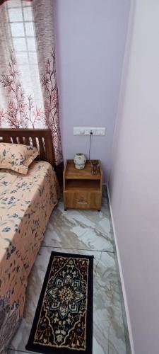 a bedroom with a bed and a rug on the floor at Diskul's HomeStay in Thiruvalla