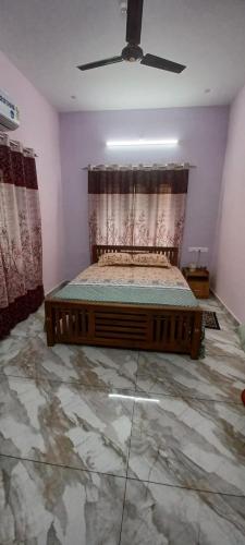a bedroom with a bed and a ceiling fan at Diskul's HomeStay in Thiruvalla