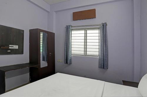 sypialnia z łóżkiem i oknem w obiekcie Hotel Sambodhi Palace w mieście Bhopal