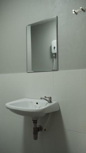 a white sink in a bathroom with a mirror at NaKan Farmstay in Kanchanaburi City