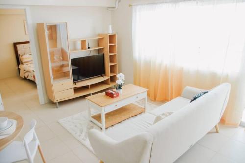 salon z białą kanapą i telewizorem w obiekcie Spacious 3 Bedroom Appartement @Avida Allgauers w mieście Iloilo