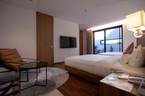 une chambre d'hôtel avec un lit et une chaise dans l'établissement Luel Hotel, à Jeonju
