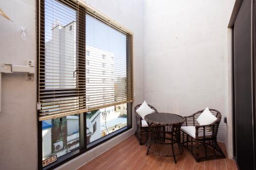 une salle à manger avec une table, des chaises et une grande fenêtre dans l'établissement Luel Hotel, à Jeonju