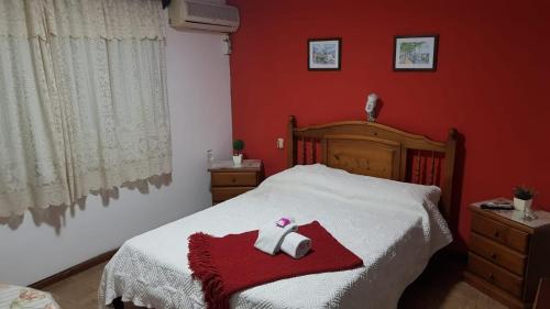 een slaapkamer met een bed met een rode muur bij Hotel Bella Unión in Bella Unión