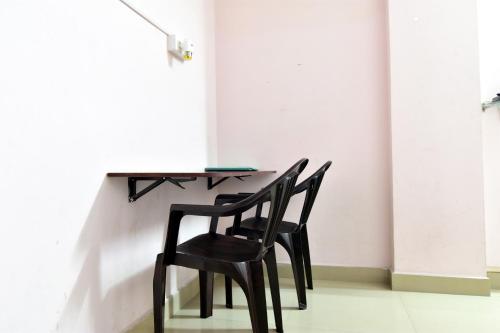 dos sillas negras sentadas en una mesa en una habitación en ROYAL GREEN AIRPORT TRANSIT ACCOMMODATION en Chennai
