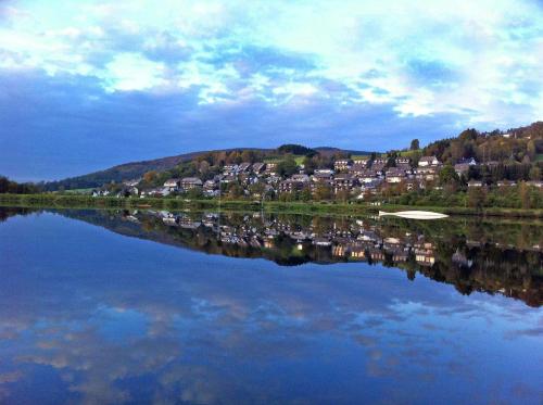 a reflection of a town on a lake with houses at Hotel Niedersfeld-Winterberg in Winterberg