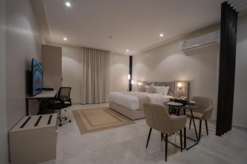Habitación de hotel con cama, mesa y sillas en Orient Jewel, en Al Khobar