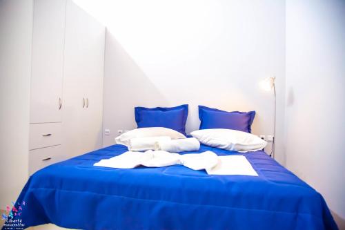 a blue bed with blue sheets and white pillows at Liberte Maisonettes in Parga