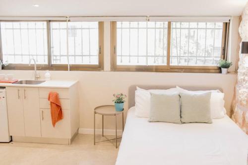 una camera con letto bianco e lavandino di Gabriel Apartments - Stone Suits JEM City Center a Gerusalemme