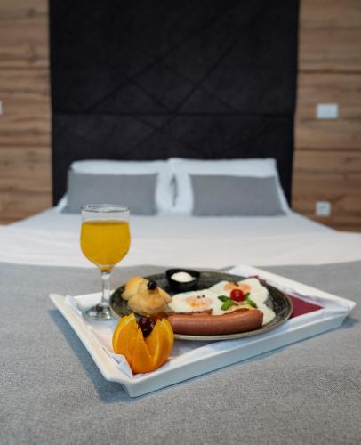 a plate of food and a glass of orange juice at Hotel Grand in Banja Luka