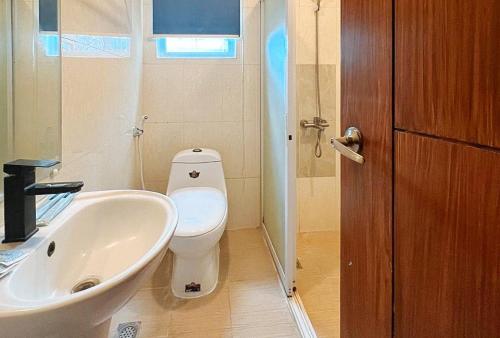 a bathroom with a white toilet and a sink at RedDoorz at Diamond Spring Hotel Angeles City in Angeles