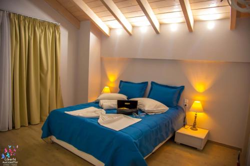 a bedroom with a blue bed with two lamps at Liberte Maisonettes in Parga