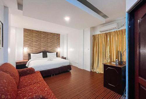 Habitación de hotel con cama y sofá en RedDoorz at Diamond Spring Hotel Angeles City, en Ángeles