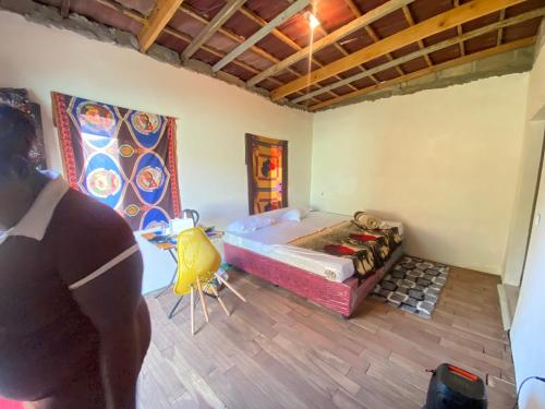 a man standing in a room with a bed at Aeropark Residencial (B&B) in Maputo