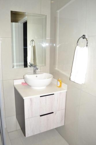 a white bathroom with a sink and a mirror at Soldout Camp 1 in Johannesburg