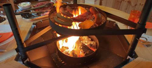 a grill with meat and food on top of it at Au Verger des Louves in Helfrantzkirch