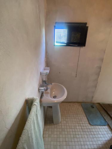a small bathroom with a sink and a window at Aeropark Residencial (B&B) in Maputo