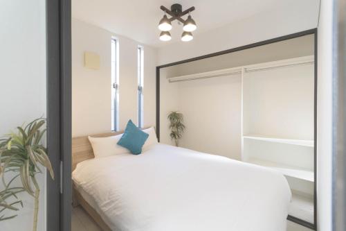 1 dormitorio con cama blanca y espejo grande en セザンヌ, en Hakata
