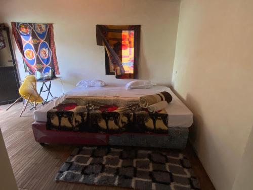 a bed sitting in a corner of a room at Aeropark Residencial (B&B) in Maputo