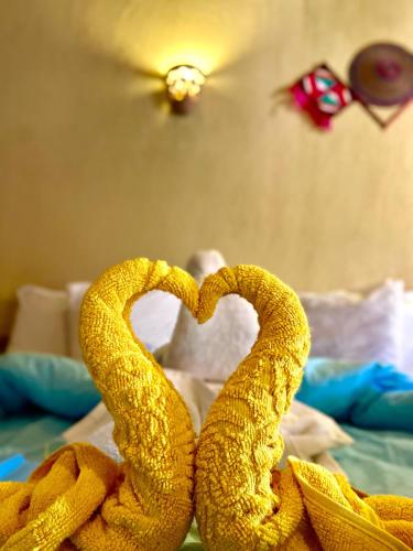 two towels in the shape of hearts on a bed at Kabara Nubian House in Abu Simbel