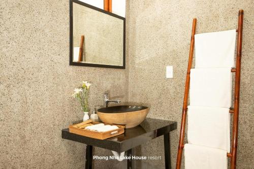 a bathroom with a sink and a mirror on a counter at Phong Nha Lake House Resort in Phong Nha